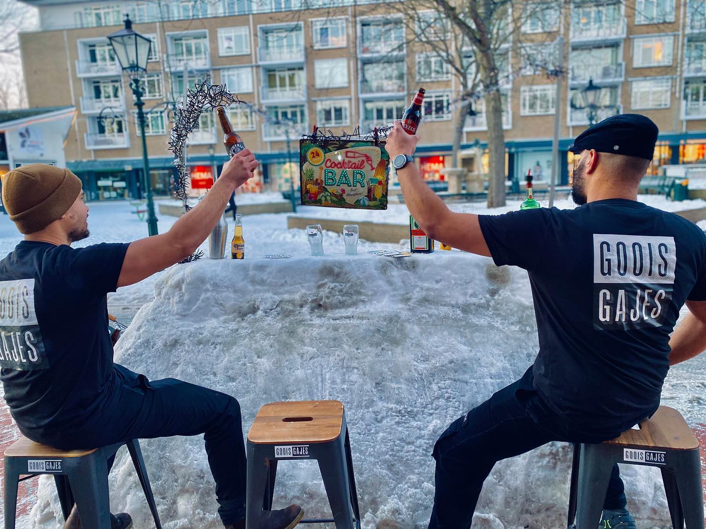 Twee broers proosten aan een zelfgebouwde sneeuwbar